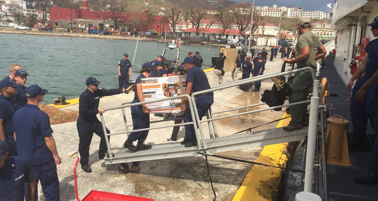 Coast Guard Cutter Joseph Tezanos crewmembers offload supplies, equipment and emergency personnel