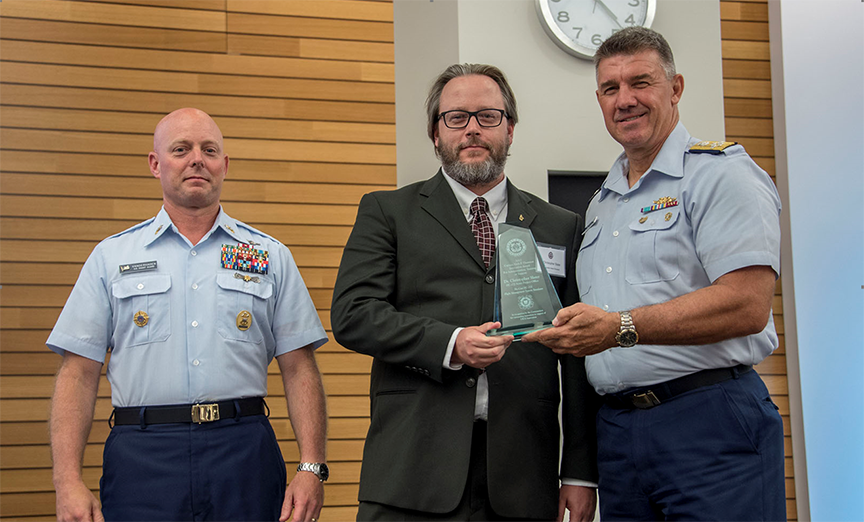 Adm. Karl Schultz, Coast Guard commandant, presents the Capt. Niels P. Thomsen Innovation Award in the Administration, Training or Support category to Christopher Slater