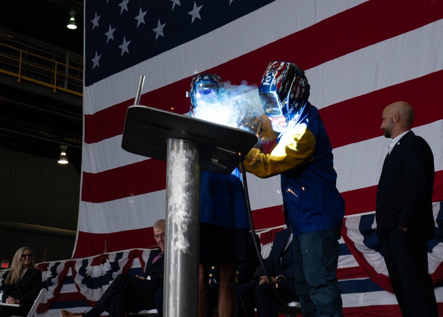 Dr. Meghan Pickering Seymour, sponsor of the Coast Guard Cutter Pickering, and Austal USA advanced welder Ravi Khamsourin apply Dr. Seymour's initials to a ceremonial plate during the offshore patrol cutter keel authentication ceremony December 8, 2025. U.S. Coast Guard photo. Dr. Meghan Pickering Seymour, sponsor of the Coast Guard Cutter Pickering, and Austal USA advanced welder Ravi Khamsourin apply Dr. Seymour's initials to a ceremonial plate during the offshore patrol cutter keel authentication ceremony December 8, 2025. U.S. Coast Guard photo.