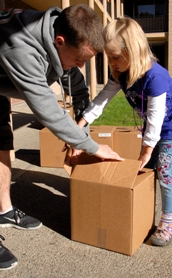 Photo of father and daughter unpacking boxes