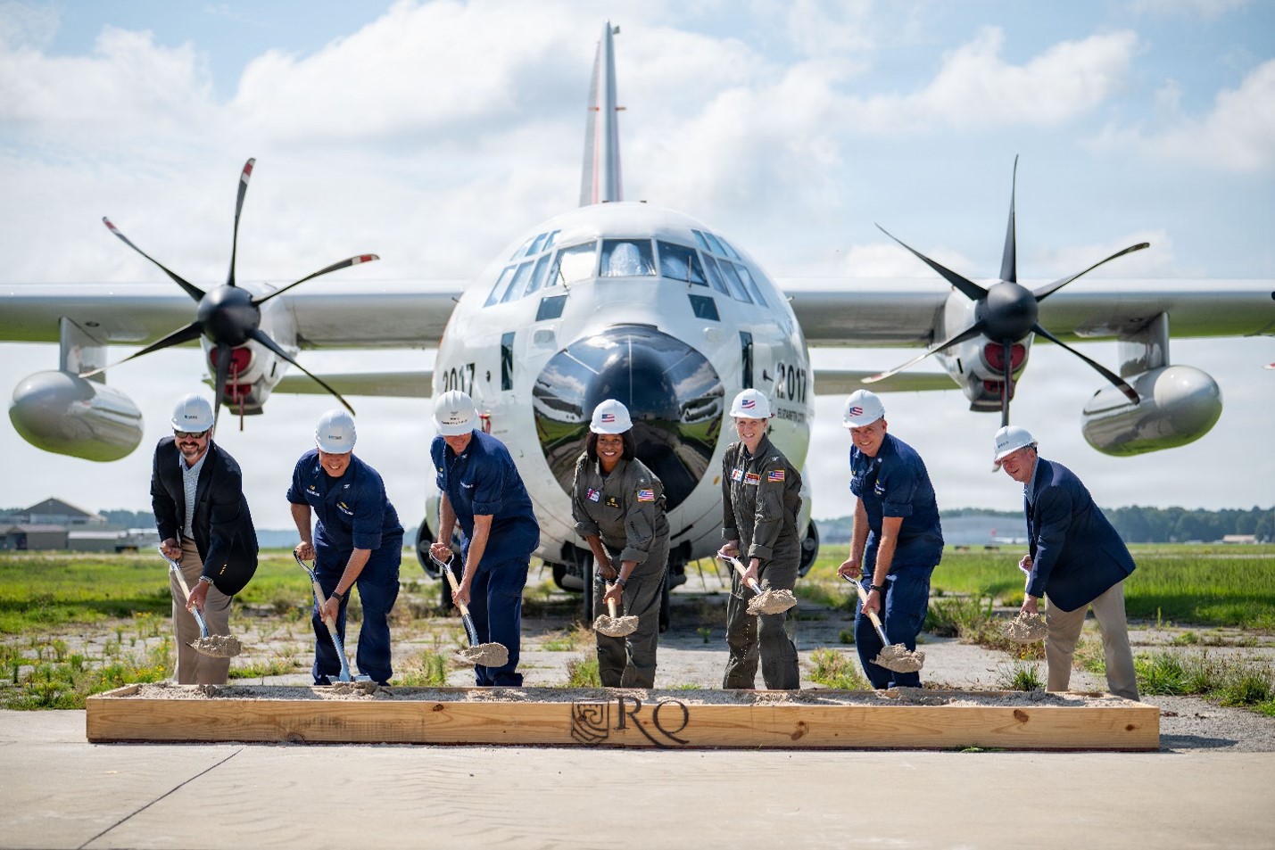 Coast Guard breaks ground on new runway with a Coast Guard airplane in the background. 